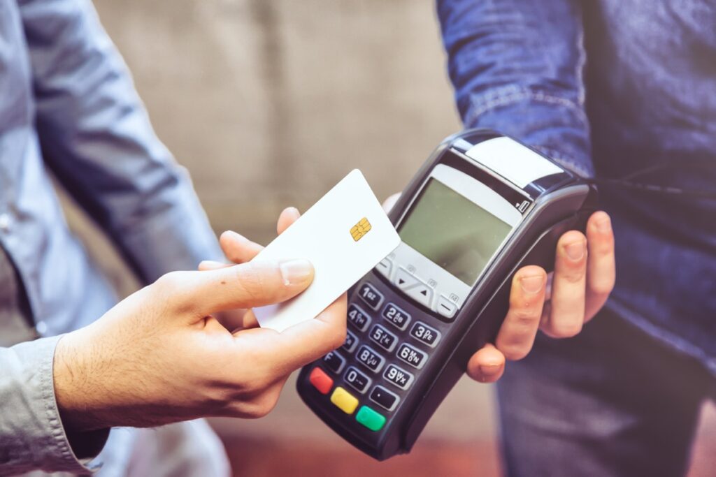 A man uses contactless payment at a debit terminal.
